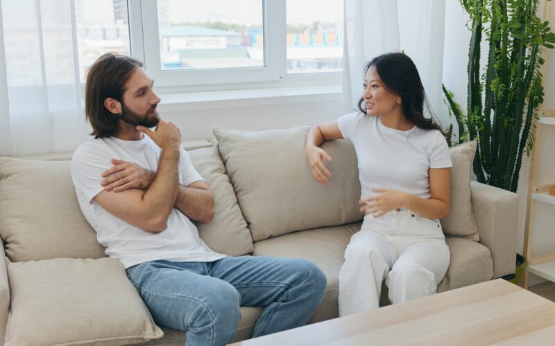 A man and a woman sitting at home on the couch